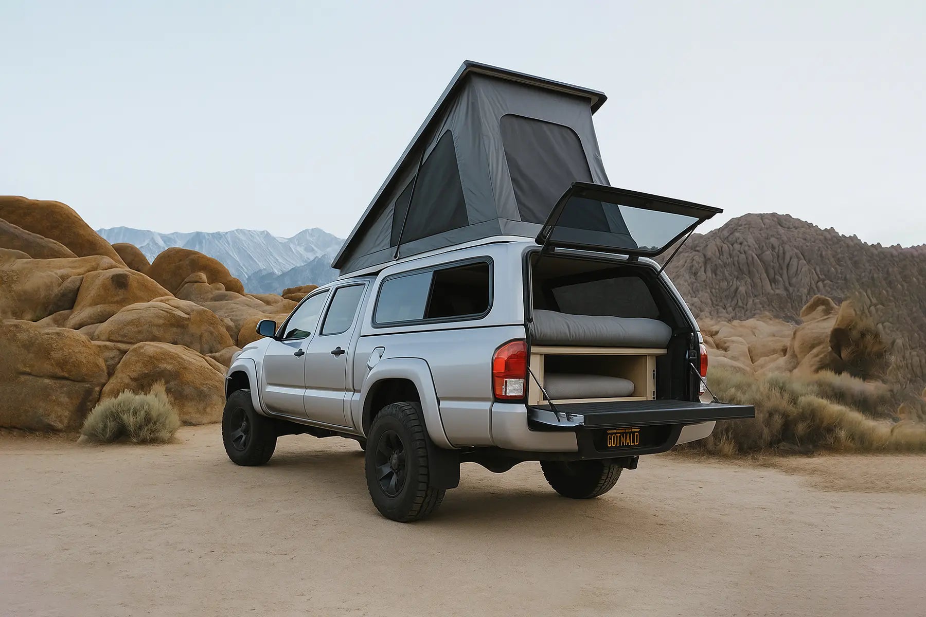 A truck with a camper cap parked by a stunningly blue lake in the Canadian Rockies at sunrise.