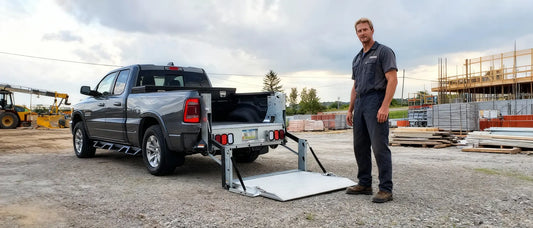 Truck liftgate lowering a heavy pallet from a box truck during a delivery